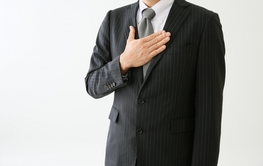 胸に手を置く男性のイメージ