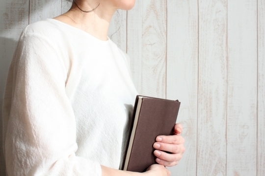 手帳を抱える女性