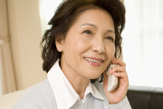 電話する年配女性