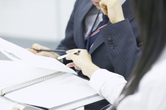 紙面で説明を受ける人